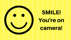 Graphic: Smiley face to left, text to right says, "Smile, you're on camera!"